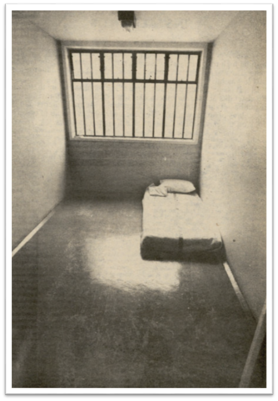 Photo of a cell in the maximum security villa.  There is a single bed on the floor and the window has bars on it